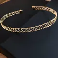 Dettaglio ravvicinato dell'elegante girocollo in metallo dorato intrecciato - Oro