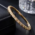 Close-up of gold-plated stainless steel bangle with embedded sparkling cubic zirconia - Gold Color (42-B-4)