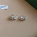 Primer plano de pendientes de aro plateados con cristal y perlas blancas. - Hebilla de oreja / Plateado