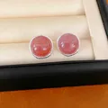 Detail view of round silver stud earrings featuring vibrant reddish strawberry quartz stones - Round Style / Pink