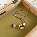 Primo piano di una collana vintage con ciondolo a ghianda in scatola rustica - Stile Ghianda con Perla a Stella (HN12993-1) / Marrone