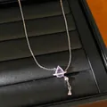 Gros plan d'un collier en argent élégant avec pendentif en zircone violette sur plateau. - Collier Goutte d'Eau / Rose