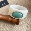Vue détaillée du bracelet jonc en acrylique marbré avec pierre verte et or - Ivoire-Vert