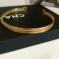Nahaufnahme eines minimalistischen goldfarbenen geflochtenen Halsreifs auf schwarzem Display - Dicht Gewebter Stil (HN12908) / Gold