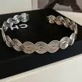 Detaillierte Nahaufnahme einer eleganten silbernen Metallkette mit gewebter Wellenstruktur - Wellenförmiger Texturstil (HN12913)