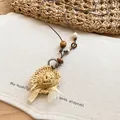 Macro detail showing texture of woven straw hat pendant on leather cord necklace - Mini Straw Sun Hat Style (48#)