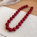 Close-up of retro ethnic style necklace with glossy red acrylic beads and gold clasp - Red (71#)