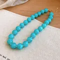 Close-up of turquoise acrylic round bead necklace with gold-toned clasp detail - Blue (72#)