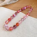 Macro detail of colorful acrylic beads with marble swirls on a vintage ethnic necklace. - Transparent Pink