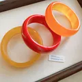 Detailansicht farbenfroher breiter Kunstharz-Armreifen in Rot-, Gelb- und Bernsteintönen - 23# (3-teiliges Set)