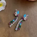 Close-up of vibrant multi-colored zircon drop earrings on a wooden texture - Stud Earrings (925 Silver Pin) / Silver - Rainbow
