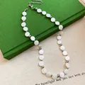 Detailansicht von weißen Muschelperlen und silbernen Perlen an einer Modekette. - Französischer minimalistischer runder Perlen-Halsketten-Stil(65#) / Silber-Weiß