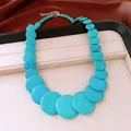 Macro detail view of a bold turquoise-style round stone beaded necklace on a display tray - Blue