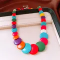 Macro detail of a chunky multi-colored flat stone beaded necklace on a jewelry tray - Colorful