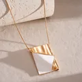 Detailed view of creative gold book pendant necklace with white enamel inlay - Flip Book Necklace / Gold-White