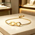 Detailed macro view of a gold infinity symbol bracelet with an adjustable box chain - Square Pearl Chain / Gold