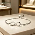 Detail shot of a silver stainless steel infinity symbol bracelet with adjustable box chain - Square Pearl Chain / Steel