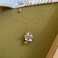 Detailopname van een druivenhanger ketting met kleurrijke stenen en zilveren blaadjes - Druivenkunst-Zilver-Lichtkoffie