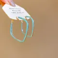Détail de boucles d'oreilles créoles losanges en émail vert menthe sur carte de présentation - Créole Losange Minimaliste (6274641558965) / Argent Bleu