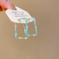 Gros plan détaillé de créoles rectangulaires torsadées argentées avec émail turquoise - Créole Losange Filetée (6274641558964) / Argent Bleu