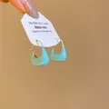 Détail macro montrant la finition en émail sarcelle des créoles à aiguille en argent - Créole en U Fer à Cheval (6274641558967) / Argent Bleu