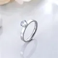 Close-up of a stainless steel ring with a sparkling round zircon stone setting. - Size 5 / Silver
