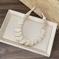 Detailed view showing the unique brown crackle pattern on a cream round bead necklace - White