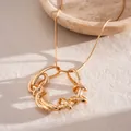 Dettaglio di un pendente geometrico attorcigliato dorato con catena a serpente - Collana / Oro