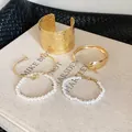 Detailed view of five-piece French style pearl and gold bracelet set on a vintage book - Five-Piece Set / 71# Bangle Gold White