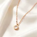 Macro view of rose gold Roman numeral necklace featuring a central crystal pendant - Rose Gold White