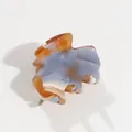 Detailed macro view of marbled acetate hair claw clip with blue and amber texture - Blue-Brown