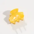 Detailed view of a bright yellow acetate hair claw clip on white surface - Yellow