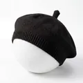 Detailed view of the black knitted baby beret featuring a soft ribbed edge texture - Black