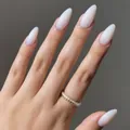 Elegant glossy milky white long almond-shaped press-on nails showcased on female hand - Almond Shape / Glossy Creamy White (CDJ-A20-154LY#2)