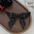 Barrette à cheveux nœud d'aile à pois Lolita gothique sur un plateau en bois sombre - Pois Noir