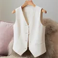 Primer plano de un chaleco de traje blanco para mujer con cuello en V y botones en percha - S / Tops / Blanco Roto
