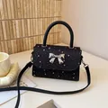 Elegante schwarze Handtasche mit silbernen Sternen und Metallschleifen-Applikation - Schwarz