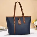 Minimalist large navy blue tote bag for women featuring brown handles and pebbled texture - Blue
