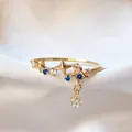 Delicate gold adjustable ring featuring blue and clear zircon stars with a charm pendant. - Adjustable Open / Deep Blue Starburst Pendant (JZ069)