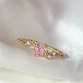 Elegant gold-plated open ring featuring a pink heart-shaped zircon and small flower accents. - Adjustable Open / Pink Heart Flower (JZ070)