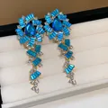 Ornate gold-plated dangling earrings with vibrant blue crystals and clear rhinestones - 17 Silver Post (Blue Crystal Luxury Drop) / Gold-Blue