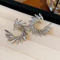Elegant U-shaped silver zircon earrings with wing design on velvet jewelry display tray - 52 Silver Post (Marquise Zirconia Wing Huggie) / Gold-Clear