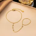 Elegantes, vergoldetes Sklavenarmband aus Titanstahl mit funkelnden weißen Steinen und Ring - Vier Weiße Strasssteine Handkette (Gold)