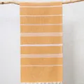 Gelb-weiß gestreiftes türkisches Strandtuch mit Quasten an einem Zweig hängend. - 100x180cm / Orange