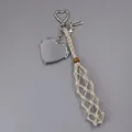 Macro view of handmade cream woven mesh pocket and silver heart locket bag pendant charm - Woven Style with Heart Mirror / Off-white