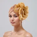 Close-up detail of elegant tan turban hat featuring a large golden organza flower. - One Size / Khaki