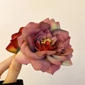 Vue détaillée d'une pince à cheveux en tissu rose séchée vintage aux pétales multiples - Pince à cheveux fleur rouge