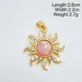 Détail d'un pendentif soleil vintage en or avec une pierre rose irisée et cristaux - Soleil Or - Rose