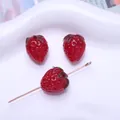 Nahaufnahme von roten Mini-Erdbeeren aus Lampwork-Glas für DIY-Schmuckherstellung - Himbeerform / Rot