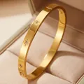 Detailed view of 18K gold-plated titanium steel bangle with engraved star patterns - Star Engraved Style (32-E-6)